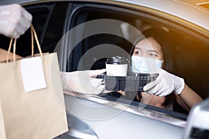 Food delivery courier give coffee cup to woman in her car,Safety food during coronavirus pandemic situation