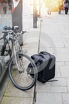 Food delivery isotherm rucksack backpack near a bike at the front door of