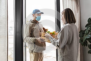 food delivery man in mask giving order to customer