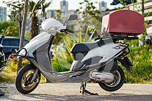 Food delivery motorbike with isothermal box parked on street