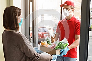 Food delivery during quarantine. Courier gives food to woman