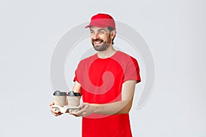 Food delivery, quarantine, stay home and order online concept. Friendly courier in red uniform cap and t-shirt, handing