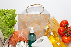 Food delivery service. Buy products online during quarantine. Healthy food and antiseptic with paper bag on white background. Sala