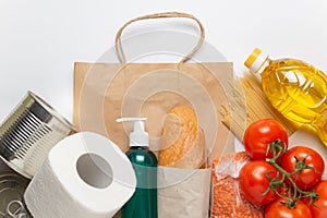 Food delivery service. Buy products online during quarantine. Healthy food and antiseptic with paper bag on white background. Sala