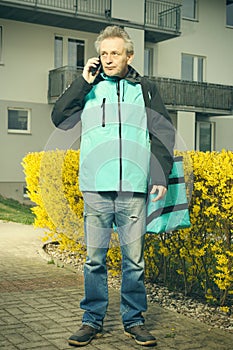 Food delivery service man waiting on sidewalk for customer