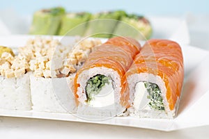 Food delivery takeaway concept. Lunch box with sushi set. Assorted sushi Philadelphia roll cheese with squid on white light