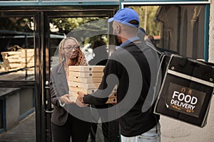 Food delivery to office, cheerful client holding pizza boxes