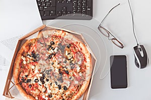 Food delivery to the workplace. Vegetarian pizza on office table. Business lunch at work