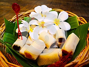 Food and dessert concept. Thai sweets are arranged on banana leaves in wicker baskets. And decorated with white flowers. Selective