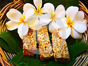 Food and dessert concept. Thai sweets are arranged on banana leaves in wicker baskets. And decorated with white flowers. Selective