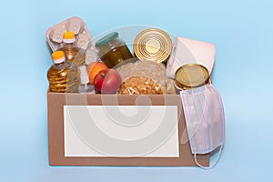 Food in a donation cardboard box, isolated on blue background,copy space. Coronavirus Relief Funds and Donations.Charity donations
