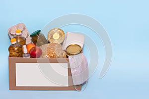 Food in a donation cardboard box, isolated on blue background,copy space. Coronavirus Relief Funds and Donations.Charity donations