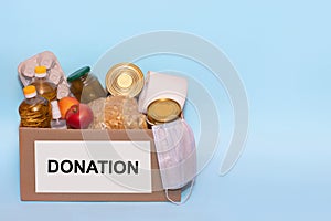 Food in a donation cardboard box, isolated on blue background,copy space. Coronavirus Relief Funds and Donations.Charity donations