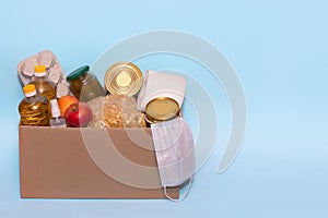 Food in a donation cardboard box, isolated on blue background,copy space. Coronavirus Relief Funds and Donations.Charity donations