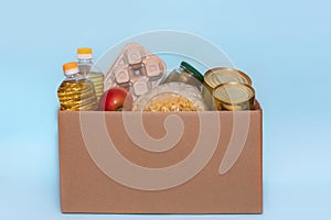 Food in a donation cardboard box, isolated on blue background,copy space. Coronavirus Relief Funds and Donations.Charity donations