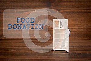 Food Donation. Miniature refrigerator on a wooden texture background