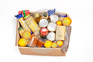 Food donations box with grocery products on white background. Top view