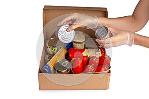 Food donations box isolated on white, hands in gloves