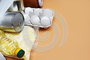 Food donations on brown background, top view with copy space