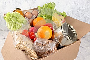 Food donations in the context of the coronovirus pandemic. Box with the necessary products, cereals, vegetables and fruits, stew