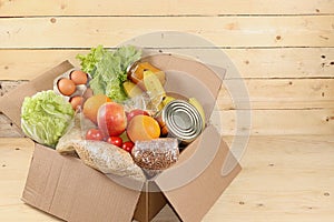 Food donations in the context of the coronovirus pandemic. Box with the necessary products, cereals, vegetables and fruits, stew