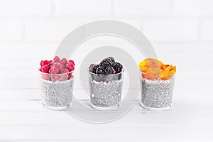Food and drink, healthy eating and dieting concept. Homemade white chia. Three glasses, raspberry, blackberry, apricot or peach.