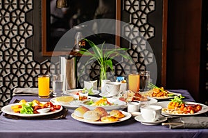 Food and drinks served on table for two persons on breakfast or brunch at morning in restaurant. Concept of weekend