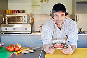 Food entrepeneur looking pleased with his quality hamburger meat photo