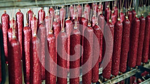 Food factory warehouse with packed meat products. Plenty of hanging smoked sausages in a storage unit