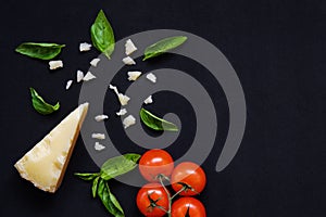 Food frame. Pasta ingredients. Cherry-tomatoes, spaghetti pasta, garlic, basil, parmesan and spices on dark background, copy