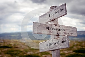 food friends sunshine text engraved on old wooden signpost outdoors in nature