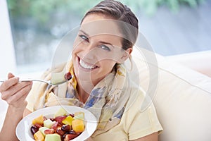Food, happy woman in portrait and fruit in salad for diet, organic meal and relax on sofa with smile for weight loss
