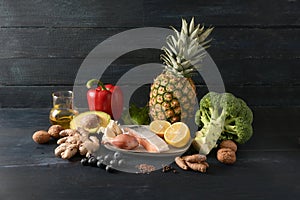 Food for health, vegetables, fish, fruits, nuts and spices for an anti-inflammatory and antioxidant diet, dark rustic wooden photo