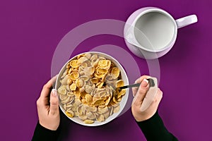 Food, healthy eating, people and diet concept - close up of woman eating muesli with milk for breakfast over purple