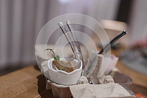 Food with herb garnished in eggshell in carton at fancy restaurant