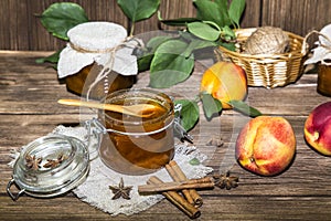 Food. Home canning. Fruit peach jam in a jar and fresh ripe peaches against a wooden table in a rural style