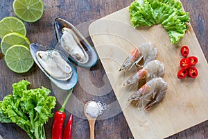 Food ingredient background. New Zealand mussel, shrimp, peppers, salad, salt , wood plate lime or lemon on table