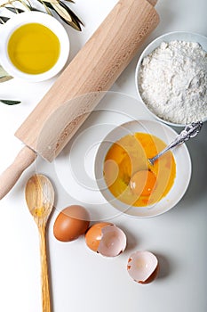 Food ingredients for bakery or homemade bread or pasta, olive oil, flour, eggs on white background.