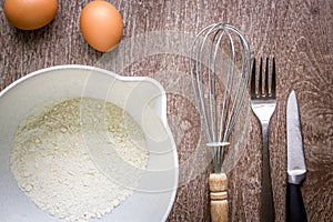 Food ingredients and kitchen utensils for cooking on wooden background