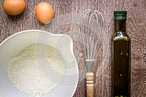 Food ingredients and kitchen utensils for cooking on wooden background