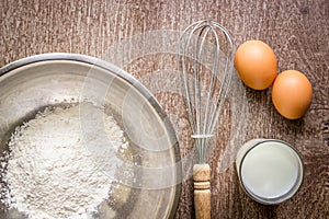 Food ingredients and kitchen utensils for cooking on wooden background