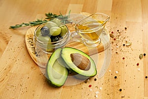 Food Ingredients. Olive Oil With Olives And Avocado On Table