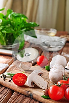 Food ingredients for pizza or pasta dishes on a wooden table in the rustic kitchen
