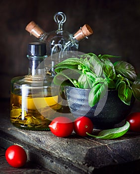 Food ingredients still life. Olive oil, cherry tomatoes, fresh basil