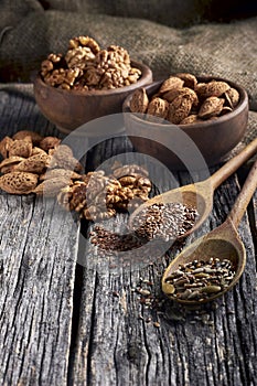 Food ingredients in wooden spoon on wooden background. Flax, pumpkin seed, sunflower and sesame