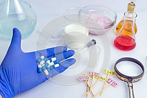 Food inspector holds pills in the palm of his hand. Laboratory Food Quality Control. Check for additives in yogurt and