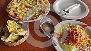 Food in Italian restaurant vegetable salad, pizza, bread sandwiches on table.