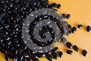 Food item - black beans grains with a warm and yellow background