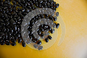 Food item - black beans grains with a warm and yellow background