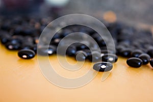 Food item - black beans grains with a warm and yellow background